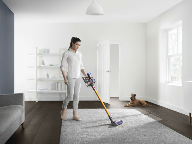 Woman Using Dyson V8 Cord-free vacuum cleaner on carpet