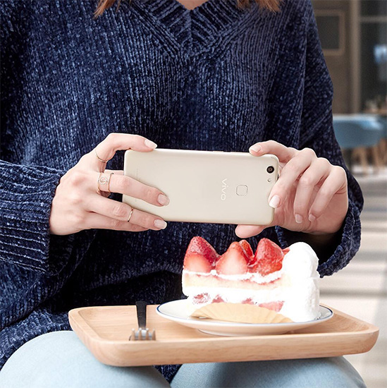 Woman taking photo of a cake using the Vivo V7+
