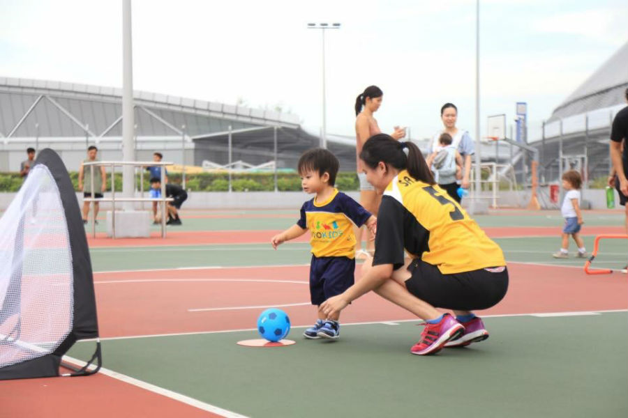 vivo Kids image of woman playing football with child