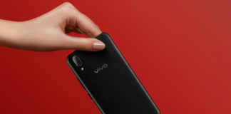 One hand passing Vivo X21 to another hand