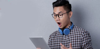 Nerd looking in surprise at his tablet