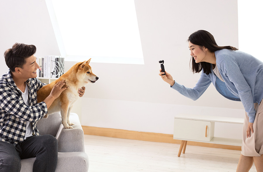 Woman taking a photo of a dog with a Mavic 2