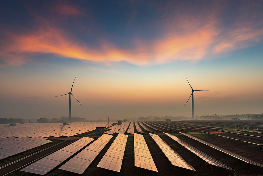 Wind and solar power plants in the dusk of the evening